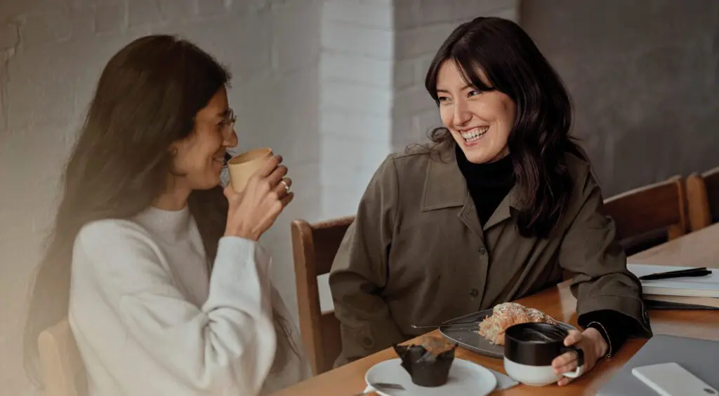 Two women talking about financial independence over coffee.