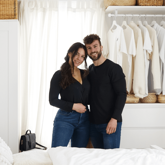 Standing centred in a white, elegantly decorated bedroom, the Hornyaks hug, facing the camera.