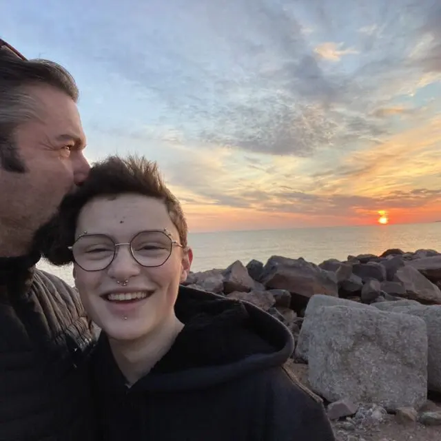 Grateful for diversity & inclusion in the workplace, Eric kisses his child’s head as the sun sets.