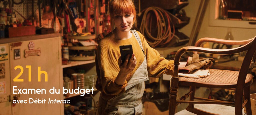 Une commerçante regarde son téléphone pour planifier son budget. 