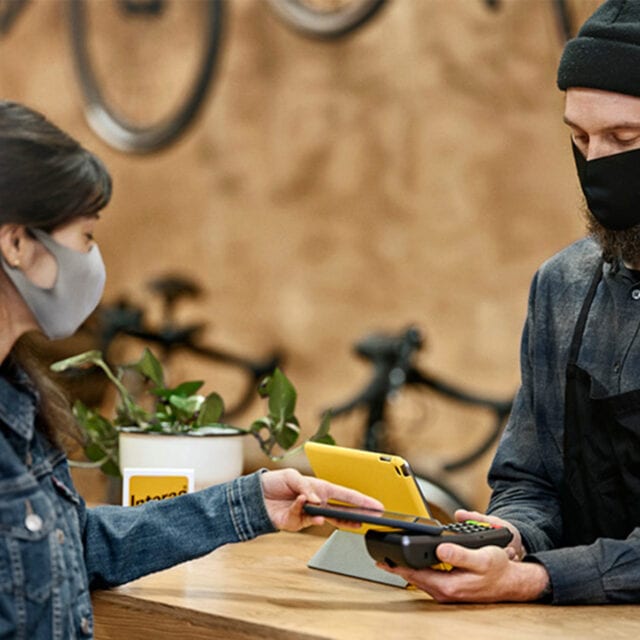 Person quickly taps their phone to pay for a purchase with a digital wallet.