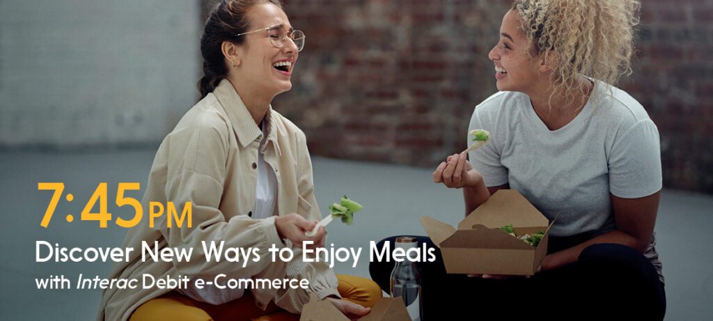 Two women sitting on the floor enjoy a meal purchased with INTERAC debit. 