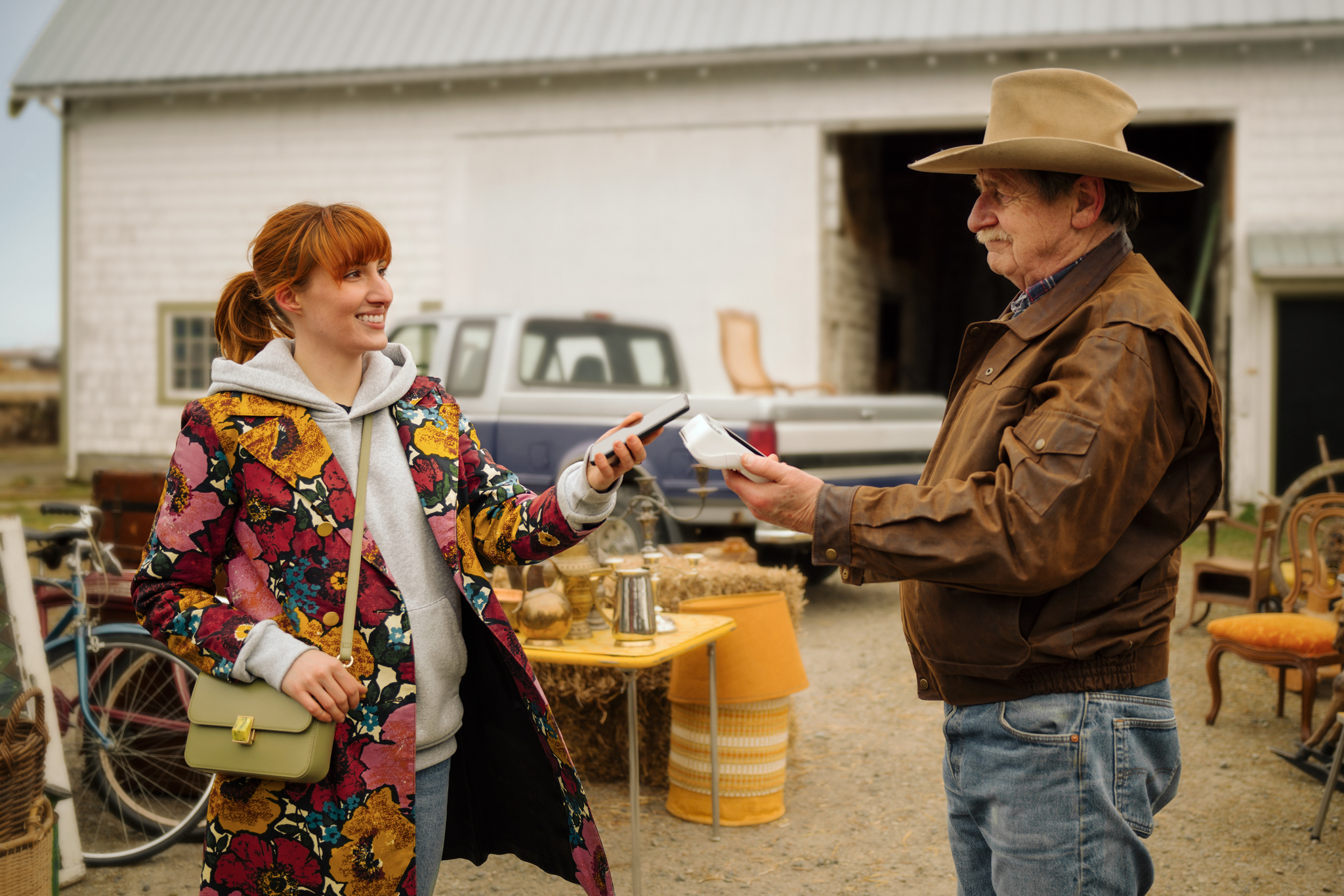 Woman uses e-wallet for purchase at a flea market for a seamless experience.