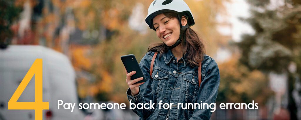 Smiling girl in white bike helmet receives payment through her phone. 