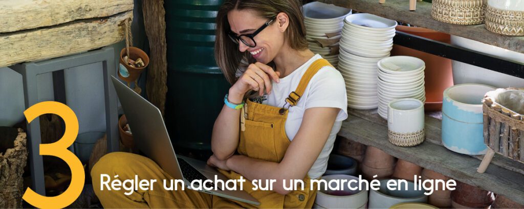 Une commerçante souriante examine ses transactions numériques sur son portable. 