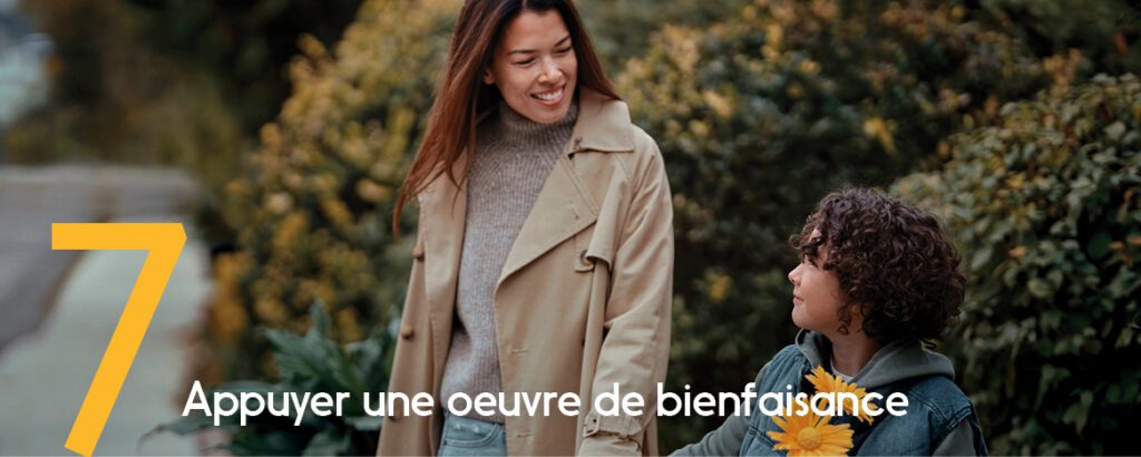 Une mère et sa fille marchent en souriant, bouquet de fleurs jaunes en main. 