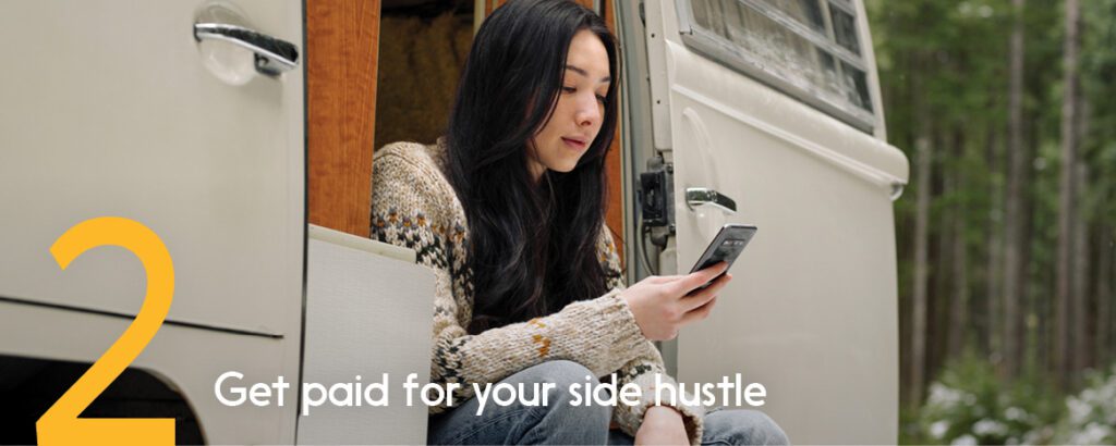 Woman sitting in her open RV is using her phone to look over her digital transactions. 