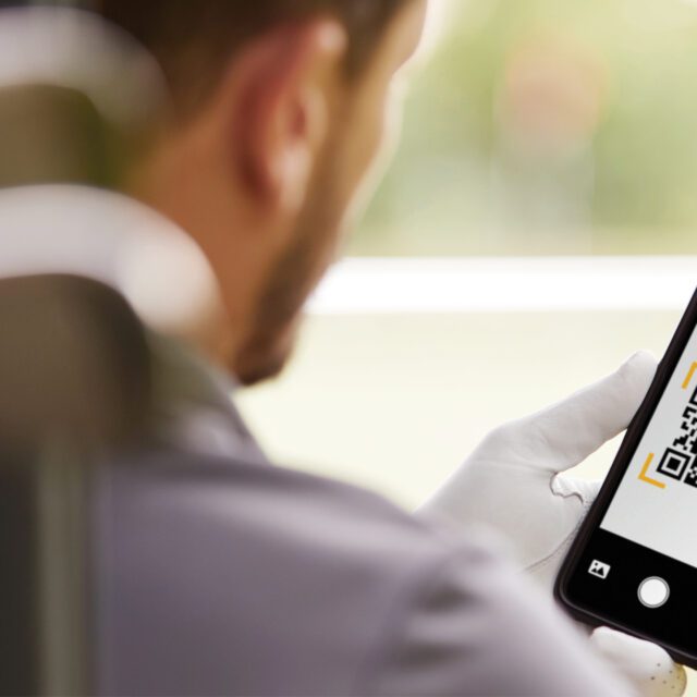 Photo: A man views his smart phone, which displays a quick-reference code code to initiate an Interac e-Transfer.