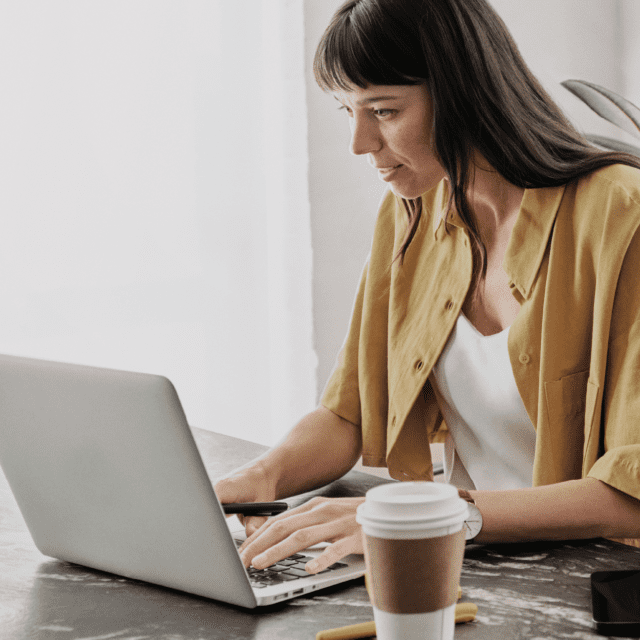 Une dame assise à un bureau utilise un portable