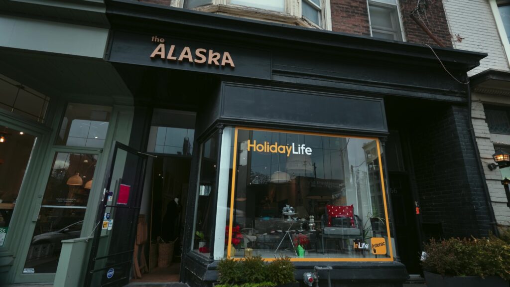 The Alaska external black storefront with Interac HolidayLife transparent billboard in display window