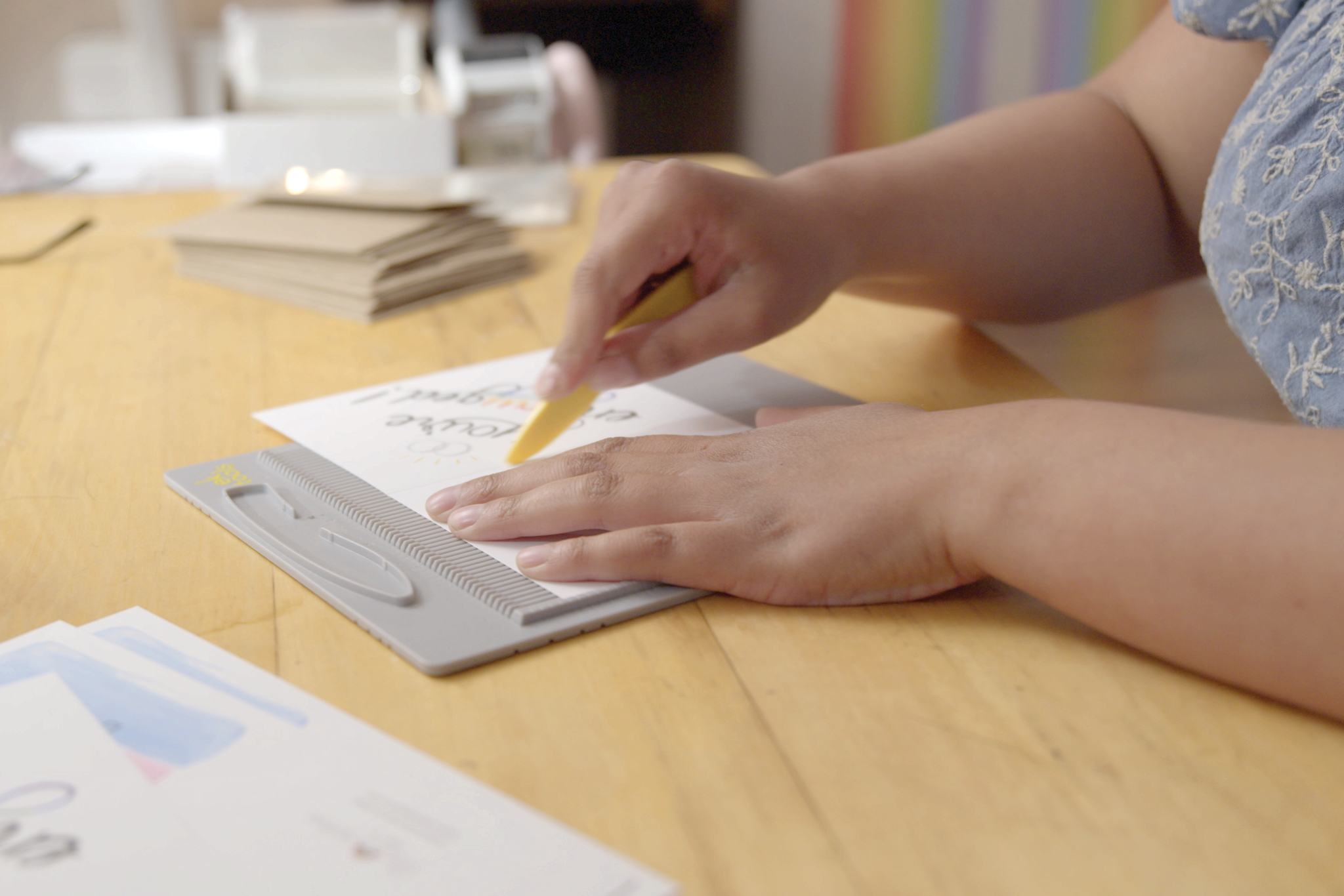 Close up of Heather’s hands as she cuts cards down to size.