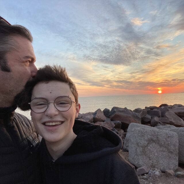 Grateful for diversity & inclusion in the workplace, Eric kisses his child’s head as the sun sets.
