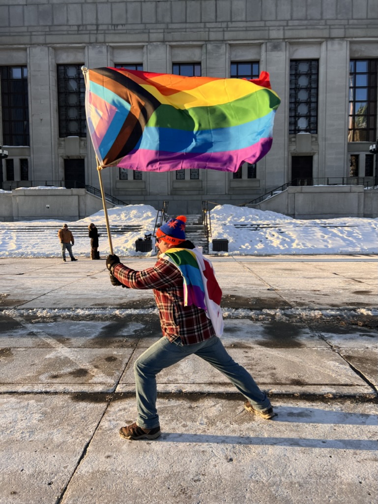 In support of diversity & inclusion, Eric proudly holds the 2SLGBTQ+ flag & wears the Canadian flag.