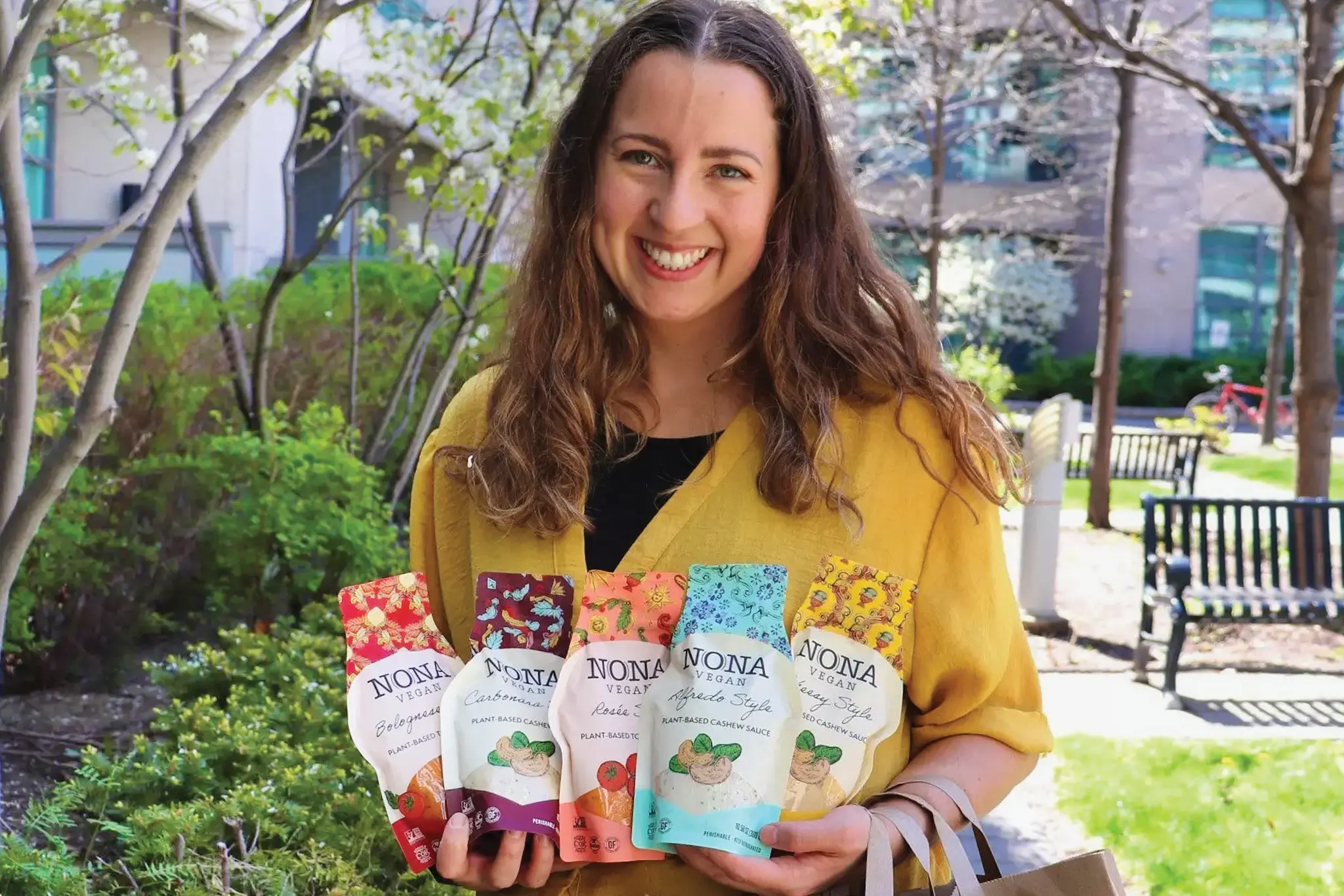 NONA Vegan CEO Kailey Gilchrist holds packages of her company’s products.