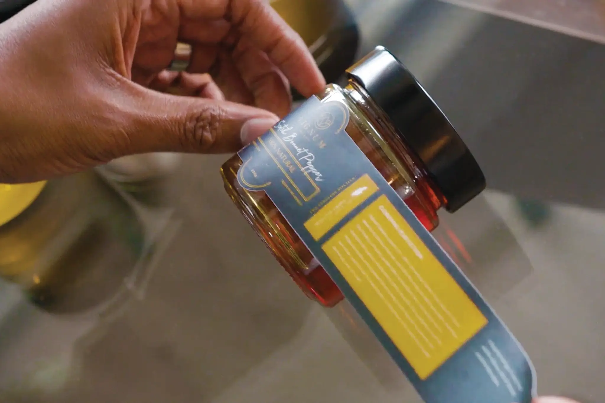 A hand holds a jar of Lignum Honey.