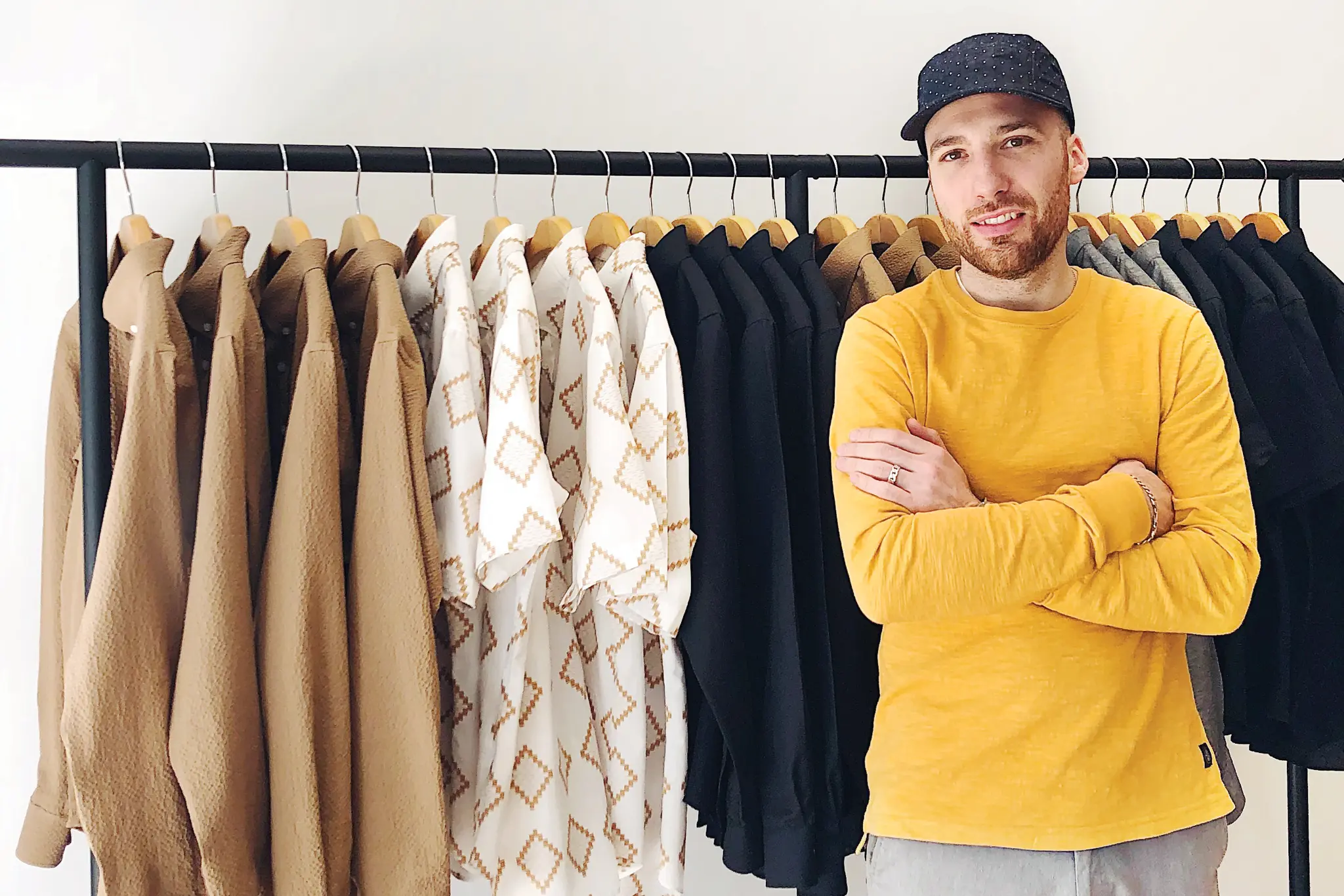 Matteo Sgaramella, fondateur de OUTCLASS, pose avec des vêtements de sa collection.