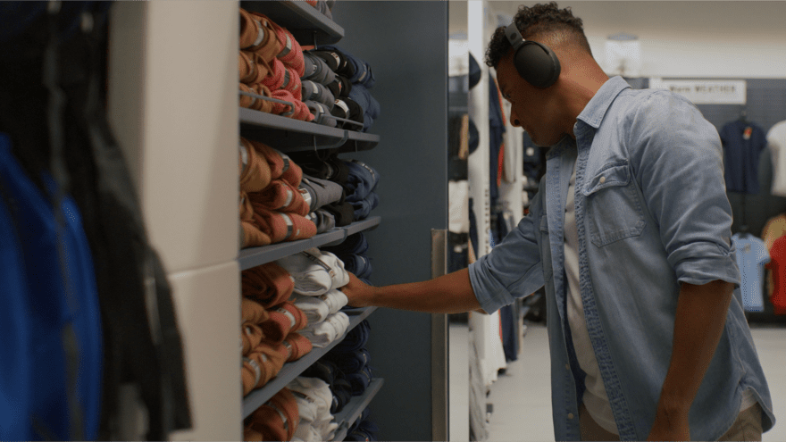 Photo of person wearing headphones and listening to music while shopping at a clothing store