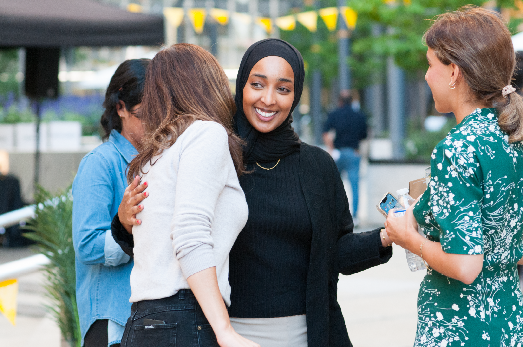 Deux employés d’Interac se donnent une accolade et sourient.